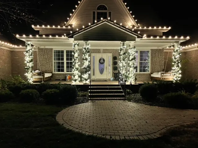 Christmas lights and garland framing a home front porch