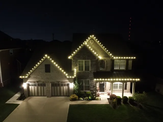 Elevated nighttime view of a home outlined in Christmas lights