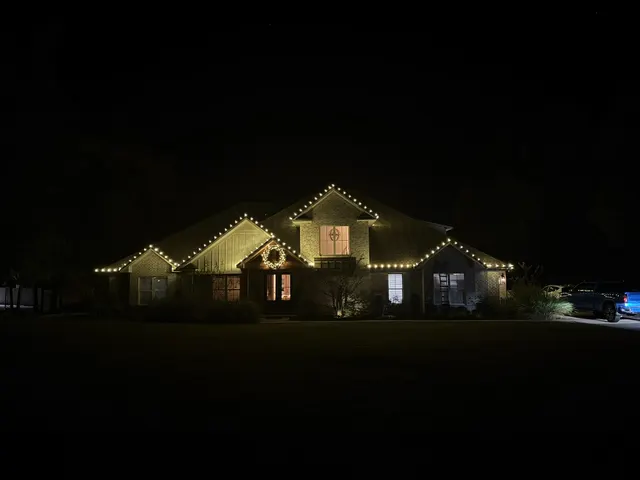 Wide nighttime view of a Christmas roofline display