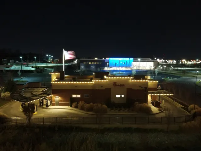 A commercial building outlined with warm roofline lights at night