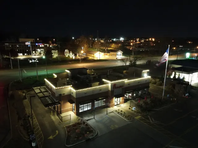 Christmas roofline lights around a commercial building at night