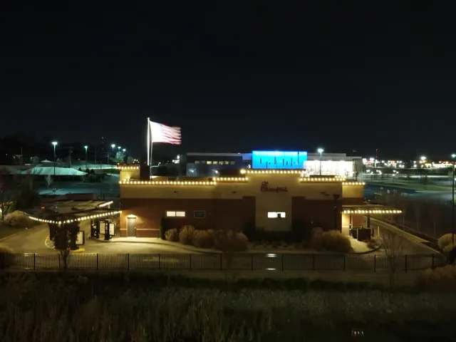Warm white lights along a commercial building roof and entry
