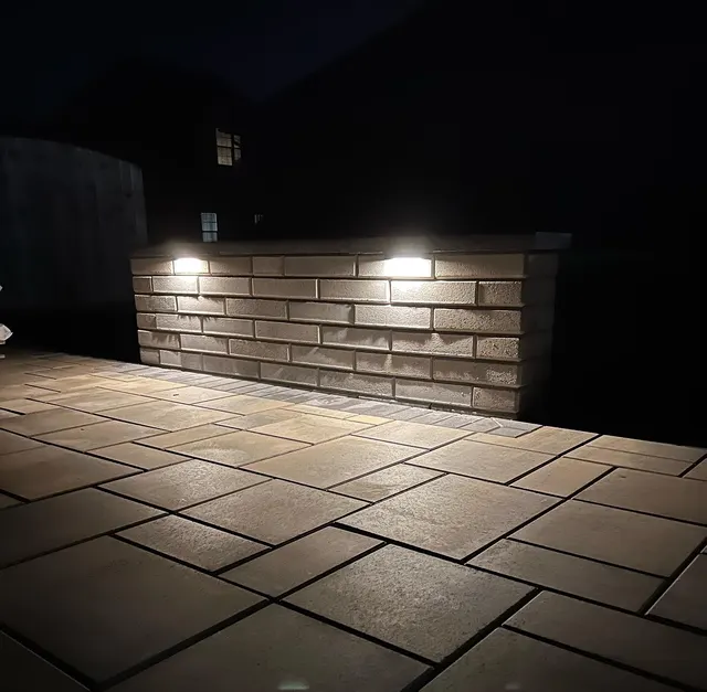 Patio seating wall illuminated by recessed lights