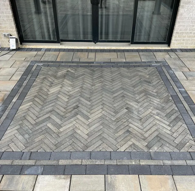 Close view of a herringbone paver pattern and contrasting border