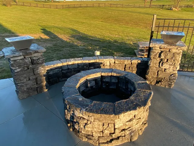 Stone fire feature with curved seating and masonry columns